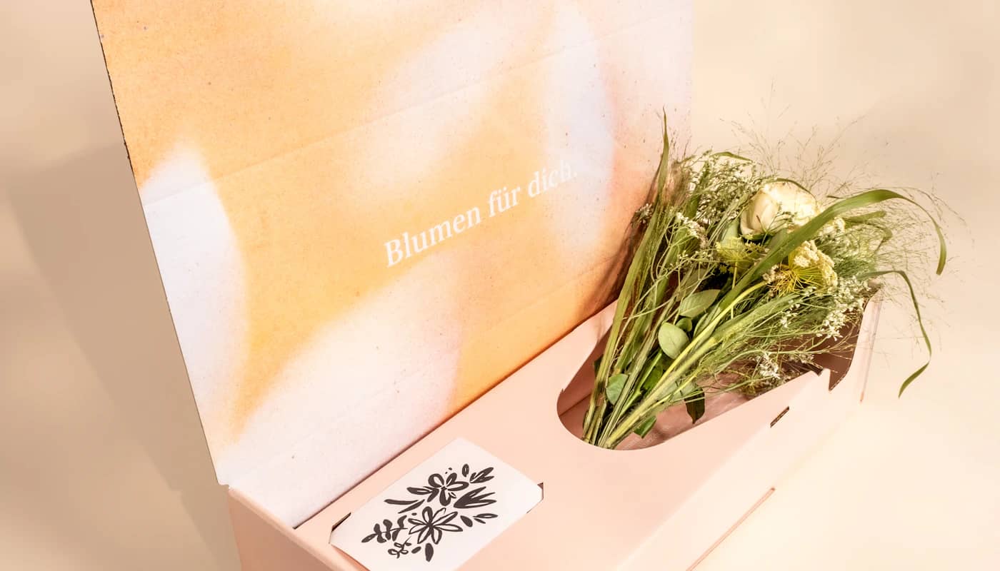 Flowers and a card in an open delivery box